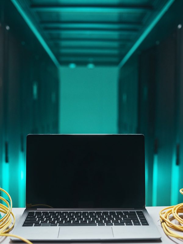 Background image of opened laptop with cables in server room, network maintenance concept, copy space